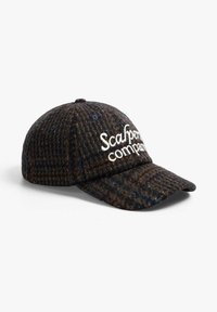Casquette à motif sombre en tissu texturé, avec un visière courbée et le logo brodé "Scalpers Company" en blanc sur le devant.