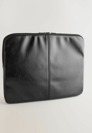 Housse pour ordinateur portable en cuir noir avec une texture lisse, des détails de couture double et une fermeture éclair sécurisée. Forme rectangulaire avec des bords arrondis.