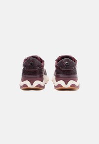 Maroon athletic shoes with mesh upper and padded collar, featuring rounded soles, a chunky design, and a textured finish.
