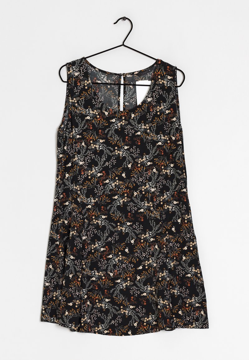 Robe noire sans manches avec un petit motif floral blanc, marron et orange suspendue sur un cintre noir contre un fond blanc.