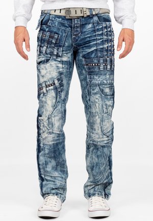 Pantalons cargo en denim bleu délavé avec plusieurs poches, clous et coutures contrastantes. Présente une coupe décontractée et un design à jambe droite.