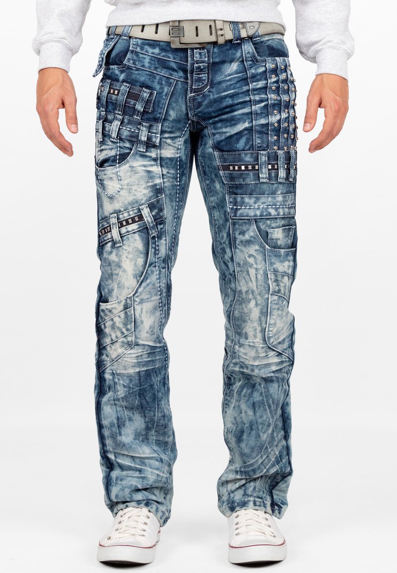 Pantaloni cargo in denim blu sbiadito con molteplici tasche, borchie e cuciture a contrasto. Presentano una vestibilità rilassata e un design a gamba dritta.