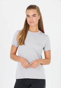 Grå kortärmad träningströja i fukttransporterande material, med rund halsringning och en diskret logotyp på framsidan.