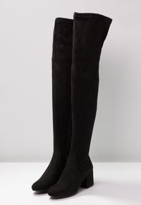 Czarne zamszowe kozaki za kolano na obcasie typu słupek, o gładkiej fakturze, bez widocznych ozdób, z bocznym zamkiem błyskawicznym do zapinania.