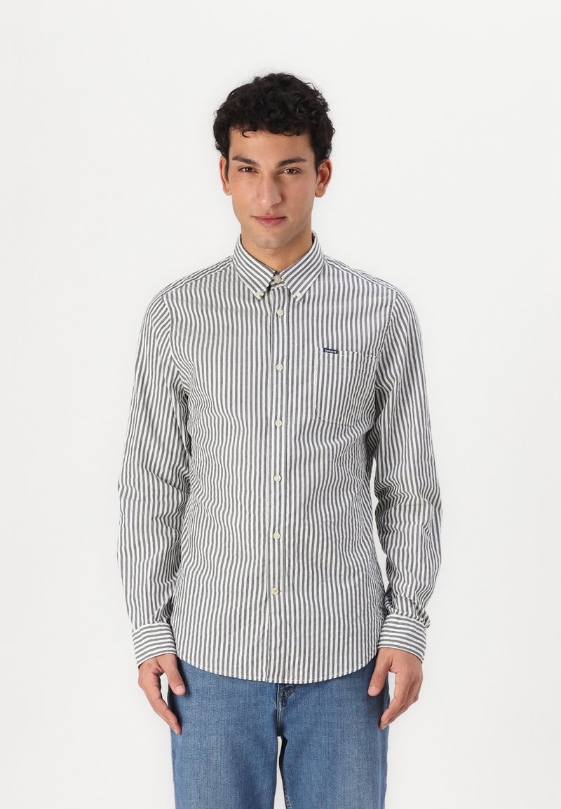 Button-up shirt in striped grey and white fabric, featuring a collar, long sleeves, and a chest pocket with a small logo.