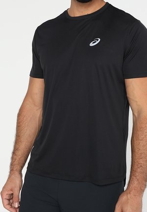 Man wearing plain black short-sleeve athletic t-shirt with a small white ASICS logo on the left chest.