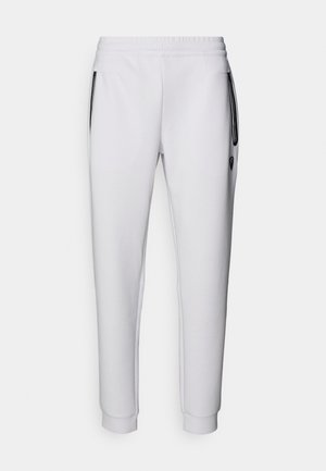 Hvide sweatpants med elastisk talje, to sidelommer, sorte lynlåsdetaljer og ribbede manchetter ved anklerne. Glat tekstur.