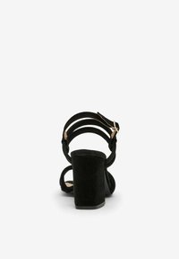Sorte ruskinds højhælede sandaler med en tyk blokhælhæl, justerbare ankelremme og åben tå design. Glat tekstur med minimalistiske accenter.