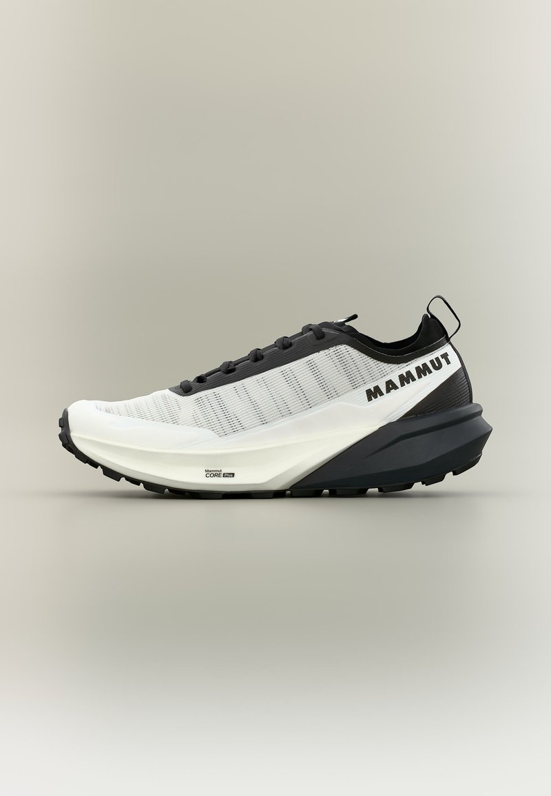 Αθλητικό παπούτσι σε λευκό και μαύρο χρώμα, ελαφρύ με πλέγμα επάνω μέρος, παχιά σόλα και λογότυπο "Mammut" στο πλάι, σχεδιασμένο για υπαίθριες δραστηριότητες.