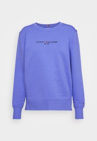 Fioletowy bawełniany sweatshirt z okrągłym dekoltem, mankietami typu ściągacz oraz logo na klatce piersiowej. Wyraźny detal w postaci haftu na dole.