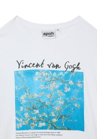 T-shirt bianco con un'opera d'arte stampata raffigurante fiori di mandorlo su uno sfondo blu, con il testo "Vincent van Gogh" sopra la stampa.