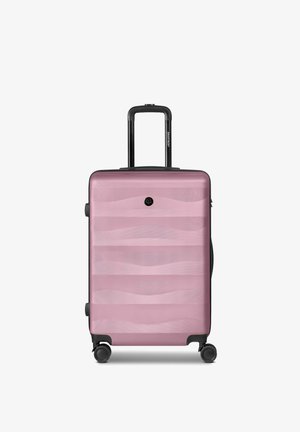 Maleta rígida rosa con asa telescópica y cuatro ruedas giratorias, con sutiles patrones ondulados horizontales en la superficie frontal.