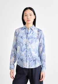 Blue floral blouse with long sleeves, button-down front, and a lightweight fabric. Features detailed flower patterns in varying shades of blue.