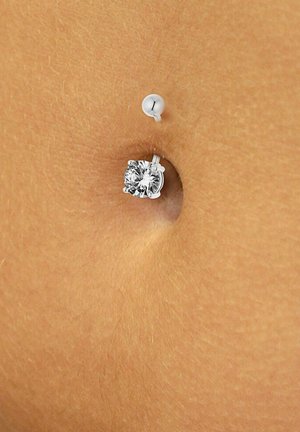 Zilveren navelpiercing met een ronde, heldere diamantachtige steen in een klauwontwerp. Achtergrond in huidskleur. Eenvoudige bal sluiting.