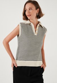 Gestreepte mouwloze trui-vest in crème en zwart, met een kraag en een drie-knopenlijst, en een geribbelde zoom voor textuurdetails.