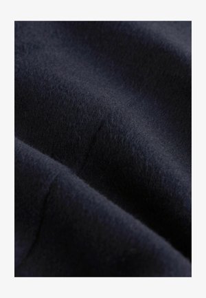 Dunkelblauer Stoff mit einer weichen, strukturierten Oberfläche, die subtile Variationen in der Tiefe und glatte Falten zeigt, geeignet für Bekleidung oder Polstermöbel.