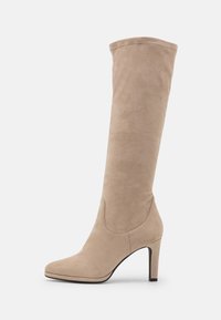 Bota de ante beige hasta la rodilla con punta afilada y tacón de aguja delgado. La textura suave y el mínimo detalle de costura realzan el diseño elegante.