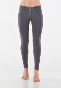 Leggings grigi con un design aderente, chiusura a due bottoni e tasche laterali. Realizzati in un materiale morbido ed elastico per il massimo comfort.