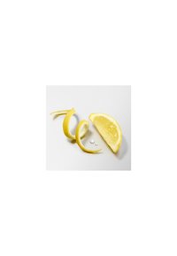 Citronbåd og spiralformet citronskal på en hvid overflade med to små vanddråber i nærheden.