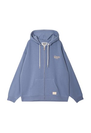Veste à capuche zippée bleue en tissu doux, comportant une poche kangourou, des cordons blancs, et un logo brodé discret sur la poitrine.
