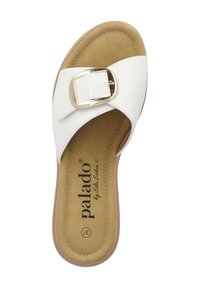 White slide sandals with a gold buckle, featuring a smooth surface and a cushioned tan insole. The sole is flat with stitching details.