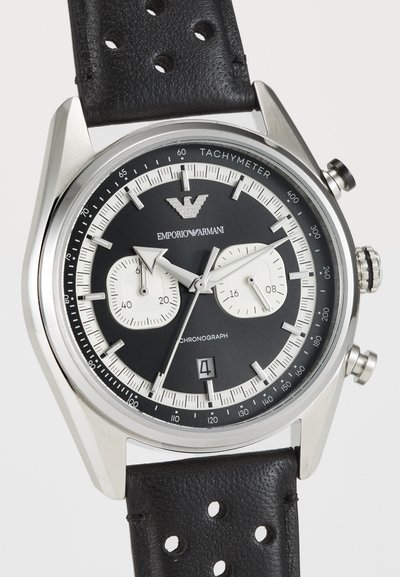 Sort chronografur med et sølvfærvet stålkabinet, to sub-dials, tachymeter-skala og perforeret læderrem.