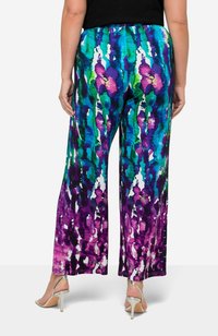 Harembyxor med ett flerfärgat mönster i blått, grönt, lila och vitt, tillverkade av ett lättviktigt tyg med en slät textur.