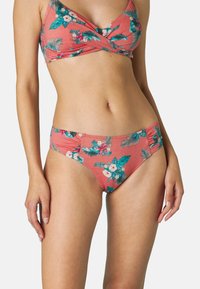 Set bikini corallo con motivo floreale e dettagli in teal e bianco. Il top ha un design incrociato, mentre i pantaloni hanno arricciature laterali.