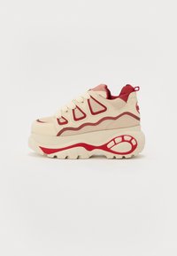 Zapatillas chunky con una combinación de colores beige y rojo, hechas de tela y goma, que cuentan con suelas gruesas, acentos rojos y un diseño texturizado.