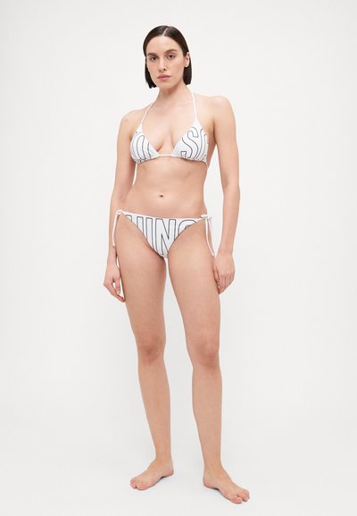White bikini set featuring a triangle top and tie-side bottoms, printed with bold black lettering, made from a smooth, stretchy material.