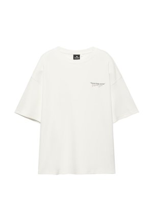 Bílá oversized tričko s krátkými rukávy, kulatým výstřihem a malým nápisem "Streets keep secrets" na levé části hrudi.