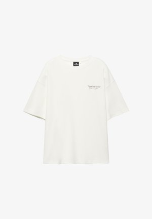 Bílá oversized tričko s krátkými rukávy, kulatým výstřihem a malým nápisem "Streets keep secrets" na levé části hrudi.