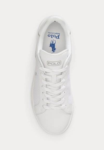Άσπρο αθλητικό παπούτσι Polo Ralph Lauren με κορδόνια, πλευρικές πάνελ από δίχτυ και μπλε λογότυπο Polo στην εσωτερική σόλα, ορατό από την πάνω πλευρά.