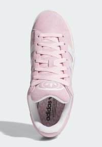 Baskets en daim rose avec des rayures blanches et des lacets. Présentent un logo rond sur la languette et un motif de semelle intérieure texturée. Design classique.