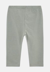 Leggings gris clair en tissu doux et extensible. Équipés d'une taille élastique et d'un design simple sans motifs ni embellissements.