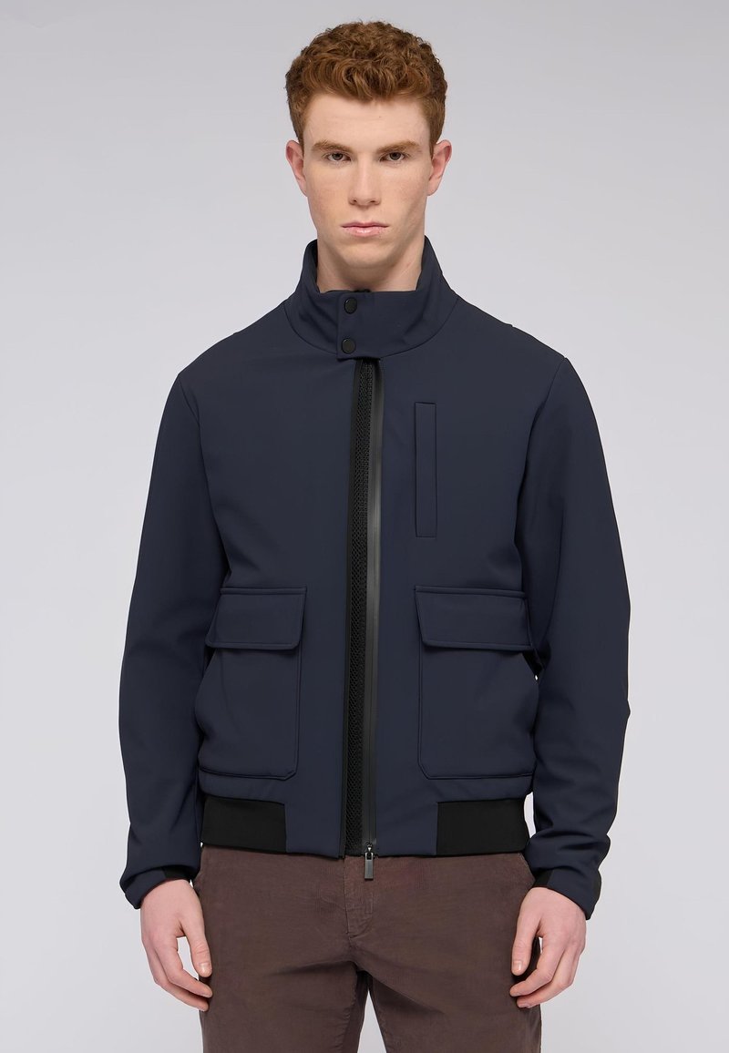 Námornícke bombardovací sako vyrobené z hladkého, elastického materiálu má vysoký límec, přední zip, dvě vakové kapsy a černé žebrované manžety.