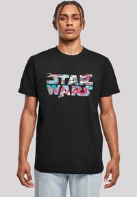 Černé bavlněné tričko s multibarevným grafickým potiskem "STAR WARS" se vířivým vzorem a ilustracemi vesmírných lodí. Standardní střih.