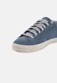 Sneaker en daim bleu avec des lacets gris, bout arrondi et semelle en caoutchouc blanc. Présente des coutures discrètes et une texture lisse.