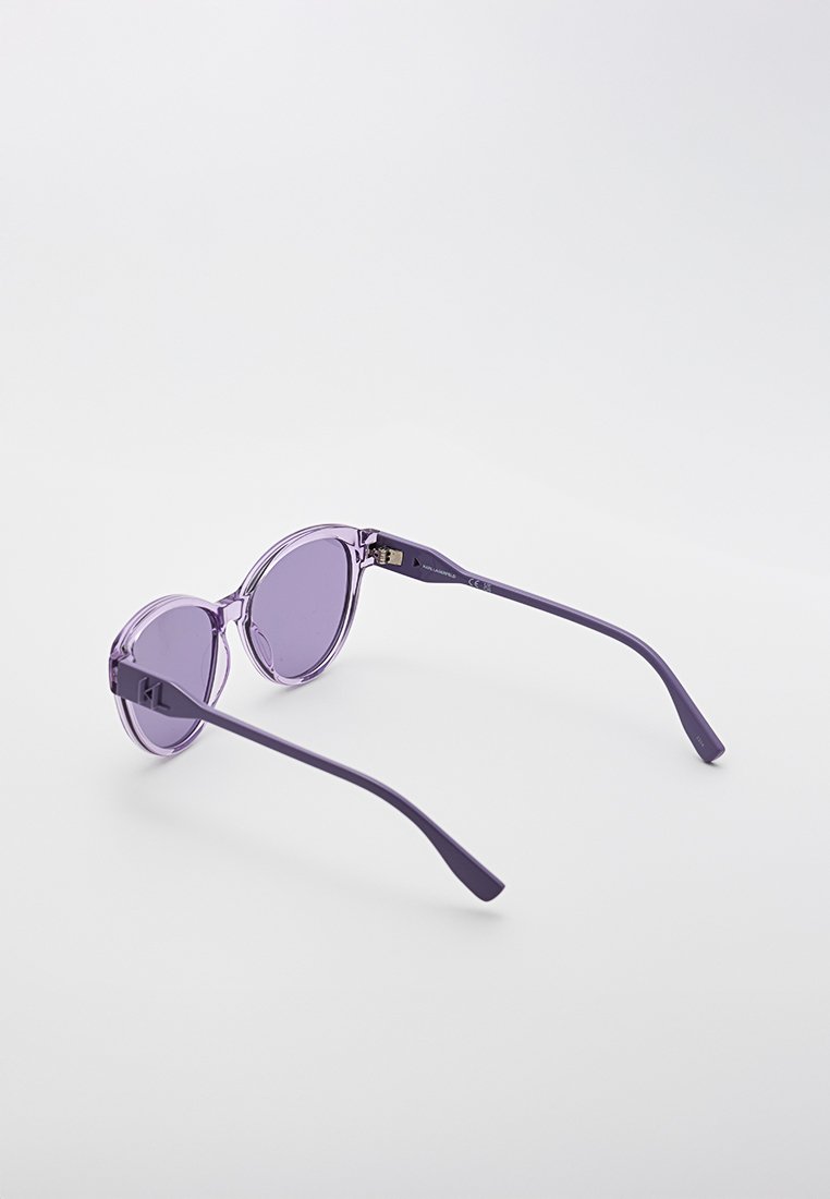 Lunettes de soleil violettes avec des verres ronds et des branches fines et courbées. Fabriquées en plastique léger, avec un logo discret à l'intérieur de la monture.
