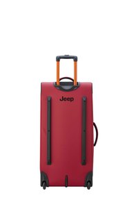 Valigia rigida rossa con manico arancione estensibile, dettagli neri e ruote. La parte anteriore presenta un logo Jeep ben visibile.