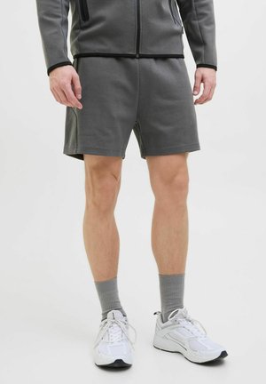 Grauathletische Shorts aus weichem Stoff mit elastischem Bund und lockerer Passform, kombiniert mit weißen Sneakers und grauen Socken.