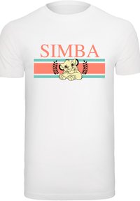 Balta medvilnės marškinėliai su grafiniu liūto kūdikio dizainu, viršuje esančiu tekstu "SIMBA" koralų oranžinės ir mėlynos juostelėse.