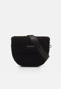 Black textured handbag made of soft, fuzzy material with a curved shape. Features a black strap embossed with "VALENTINO." Gold hardware accent.
