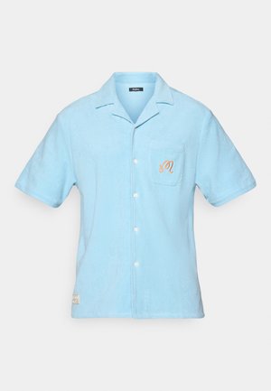 Lichtblauw overhemd met korte mouwen, gemaakt van zachte badstof. Heeft een kraag, een borstzak met geborduurd detail en een knoopsluiting.