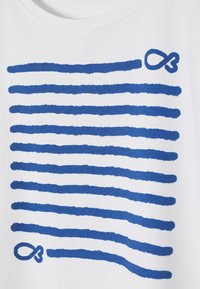 T-shirt blanc avec des rayures en coup de pinceau bleu et un design de symbole de l'infini en haut à droite. Tissu doux avec une texture lisse.