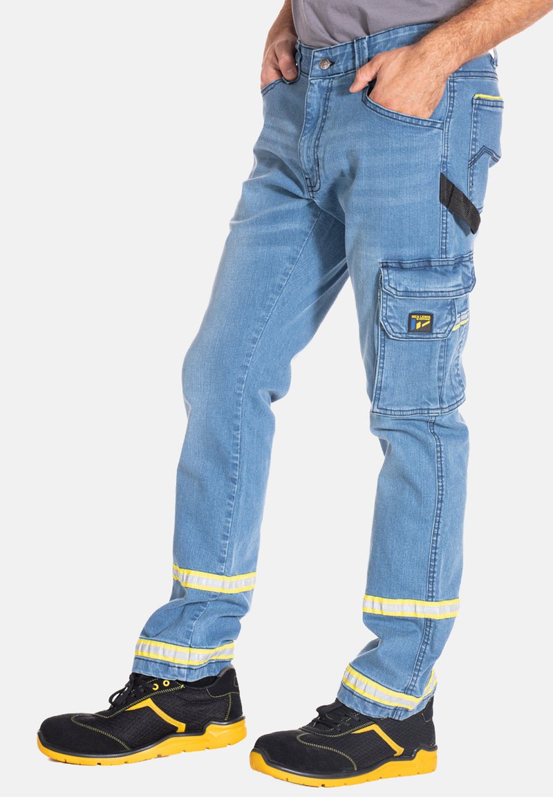 Pantalons de travail en denim bleu avec des poches cargo, des accents réfléchissants jaunes et une coupe droite, associés à des chaussures de sécurité noires et jaunes.