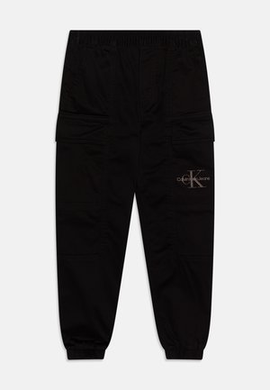 Schwarze Calvin Klein Cargo-Hose mit elastischem Bund und Bündchen, Fronttaschen und Logo am rechten Oberschenkel.