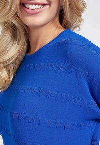 Suéter de punto azul con rayas horizontales texturizadas. Cuello redondo, tela suave y diseño sin costuras. Sin patrones visibles, acabado liso.