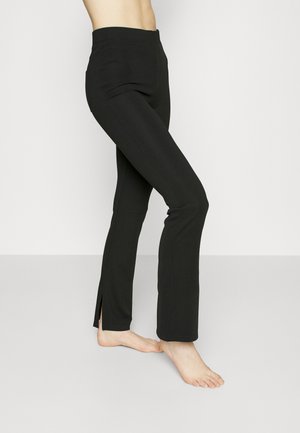 Schwarze, ausgestellte Hose mit elastischem Bund, glatter Textur und seitlichen Schlitzen am Saum. Maßgeschneidert für eine schlanke Silhouette.