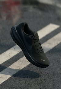 Svart Nike löparskor med en texturerad ovandel, elegant design och en vadderad sula. Har en logotyp på sidan och snörning för en säker passform.